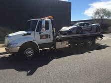 silver luxury car on tow truck