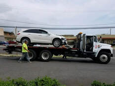 white suv car getting towed by white truck