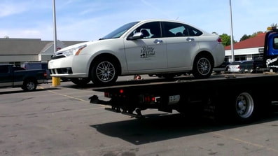 white car on tow truck